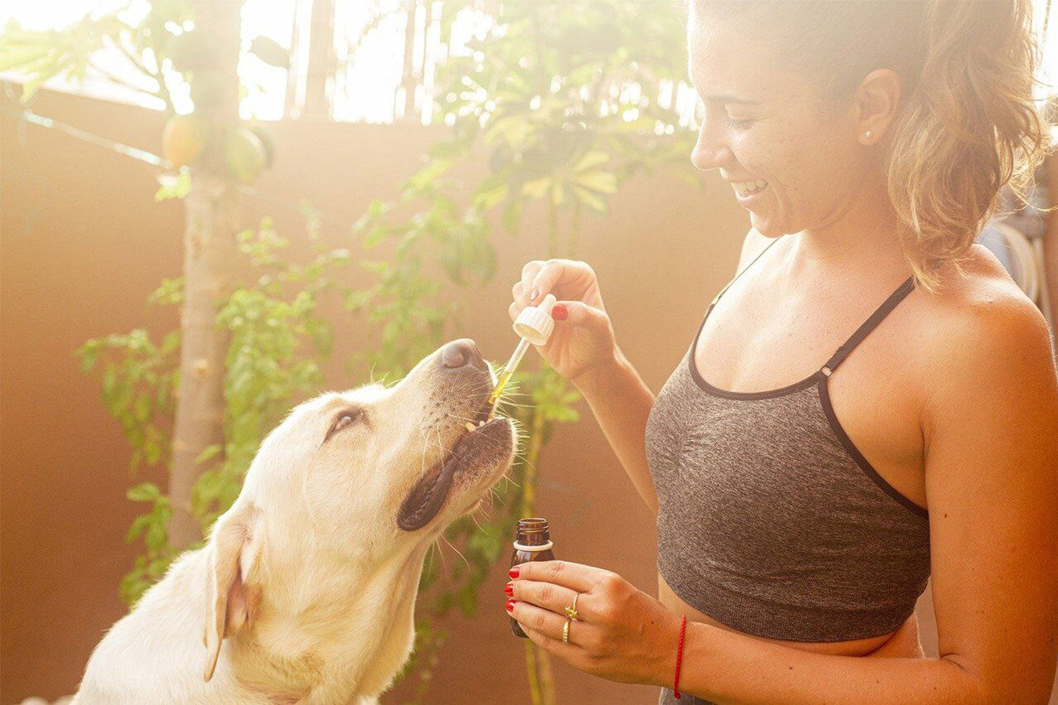 Woman feeding her dog Paramount Pet Health Fish Oil